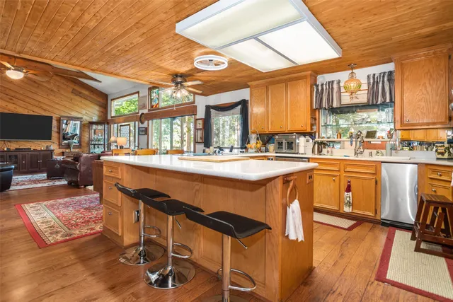 a dining hall with stainless steel appliances granite countertop a sink and wooden floors