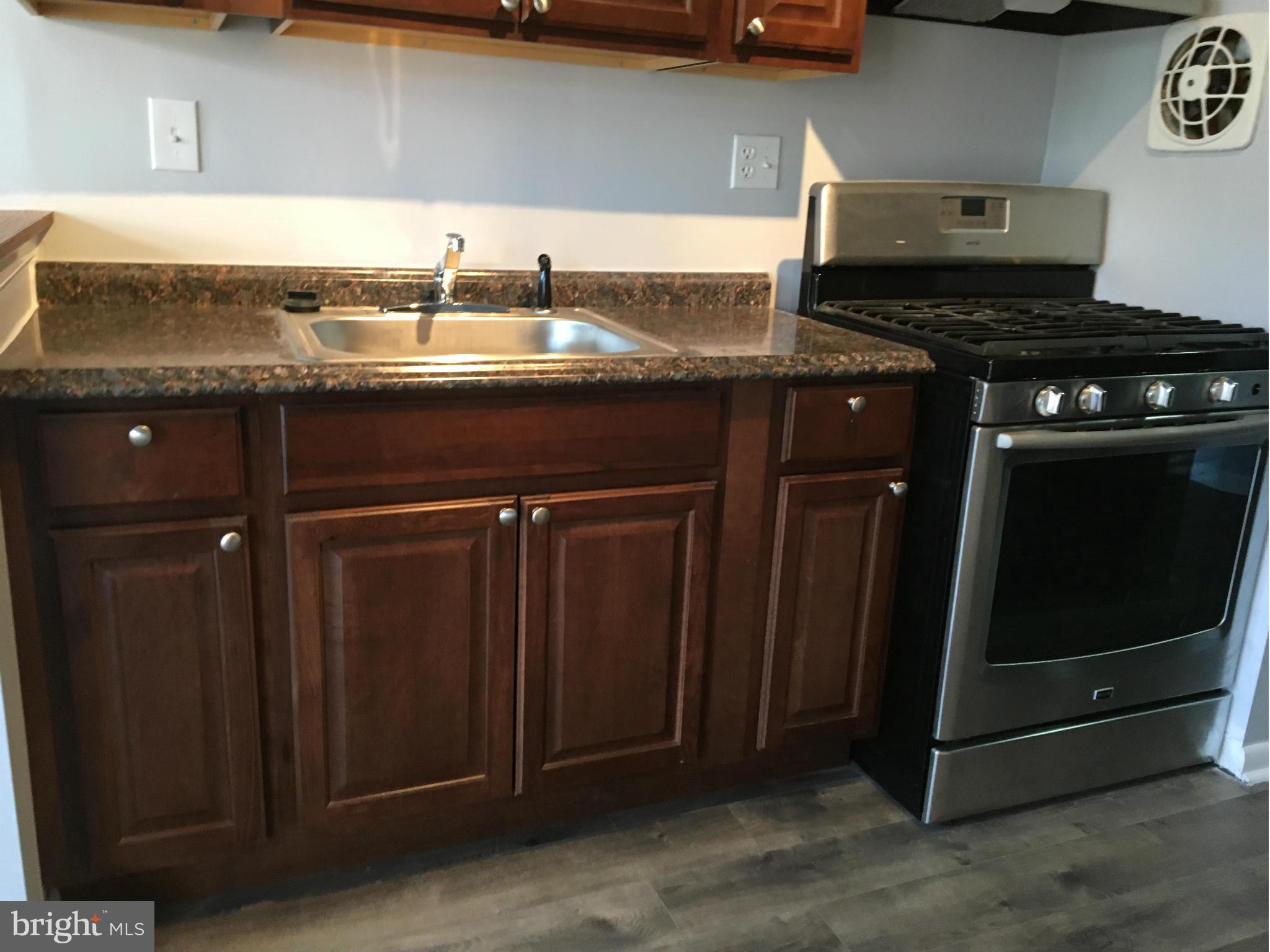 3803 St Barnabas Road, Unit T Suitland, MD 20746 - Photo 4 of 13 a kitchen with granite countertop a sink and a stove