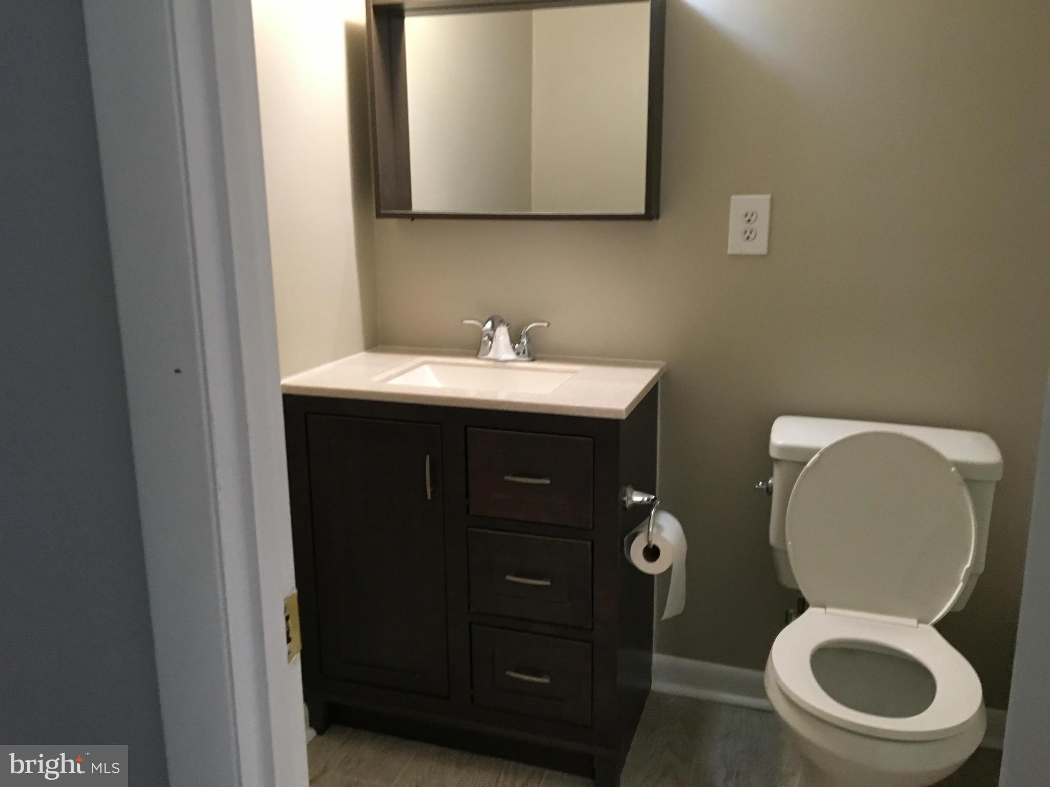 3803 St Barnabas Road, Unit T Suitland, MD 20746 - Photo 8 of 13 a bathroom with a toilet a sink and mirror