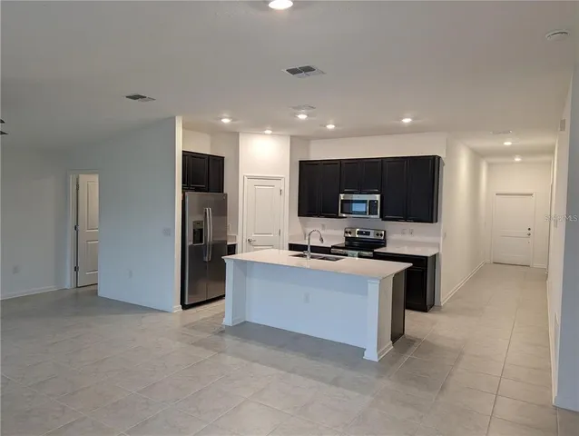 a kitchen with stainless steel appliances a stove top oven a sink dishwasher a refrigerator and a oven