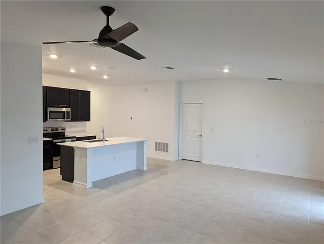 a large kitchen with stainless steel appliances a large counter top