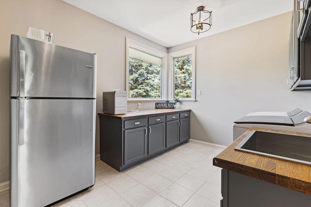 2570 Jewett Road Powell, OH 43065 - Photo 34 of 104 • Ceramic tile flooring • Grey painted walls • Cabinets with wood countertops • Ceiling light • Wall cabinets • Single bowl stainless steel sink with sprayer • Frigidaire® refrigerator remains • Washer & dryer are negotiable