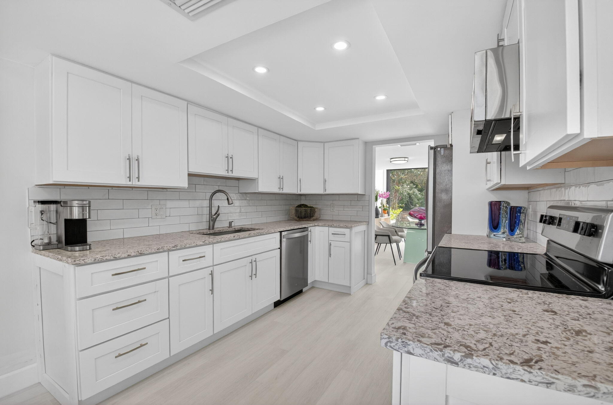 3708 Bridgewood Drive Boca Raton, FL 33434 - Photo 12 of 37 a kitchen with granite countertop a sink stainless steel appliances and white cabinets
