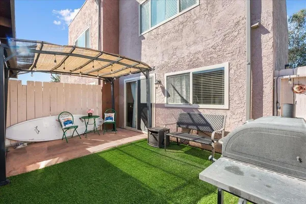 a backyard of a house with table and chairs