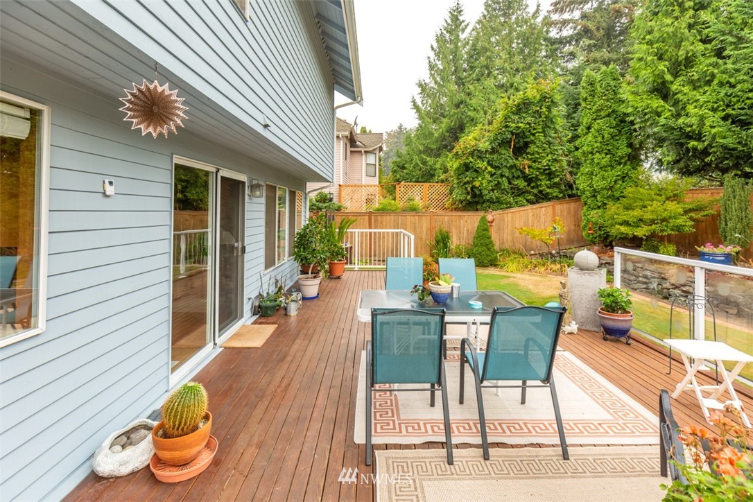 15720 Southeast 184th Street Renton, WA 98058 - Photo 13 of 30 a view of a patio with table and chairs potted plants with wooden floor and fence