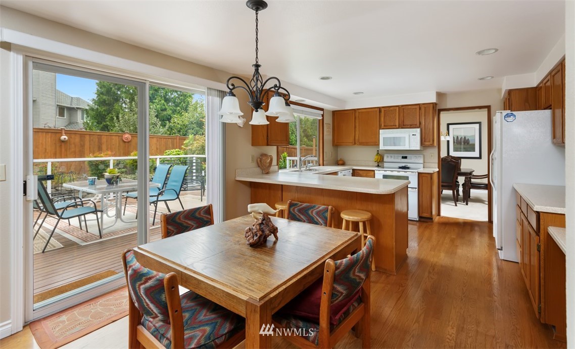 15720 Southeast 184th Street Renton, WA 98058 - Photo 19 of 30 a view of a dining room and livingroom with furniture wooden floor a chandelier