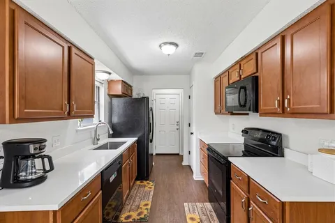 a kitchen with stainless steel appliances sink refrigerator and cabinets