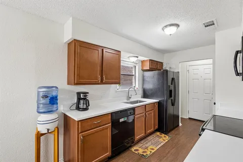a kitchen with granite countertop a stove top oven a sink a dining table and chairs