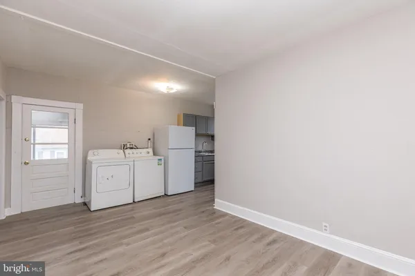 a view of a kitchen with wooden floor and white walls