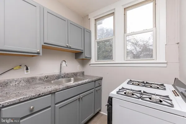 a kitchen with granite countertop a sink stove and cabinets