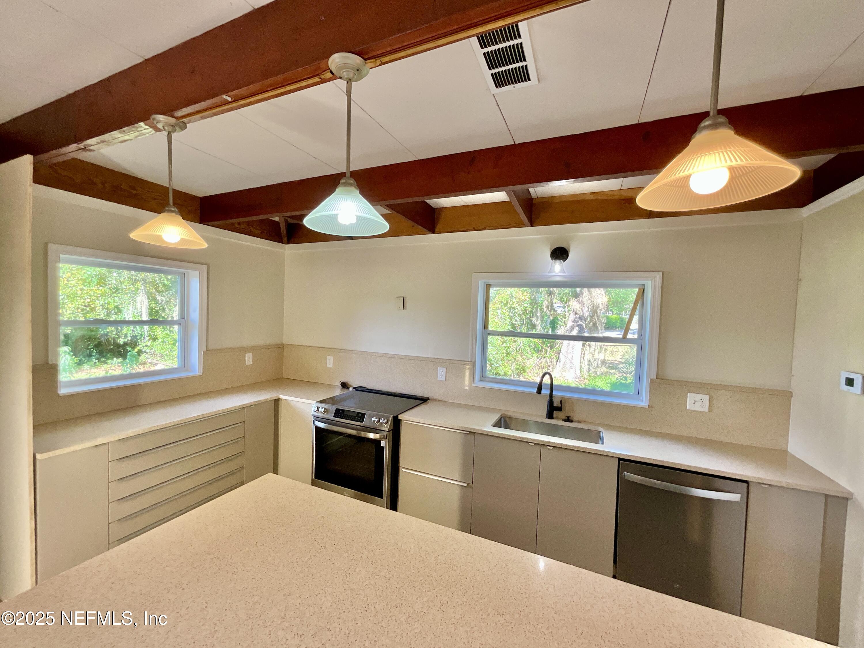 145 Depot Road Hawthorne, FL 32640 - Photo 23 of 73 a kitchen with stainless steel appliances a sink a stove and a window