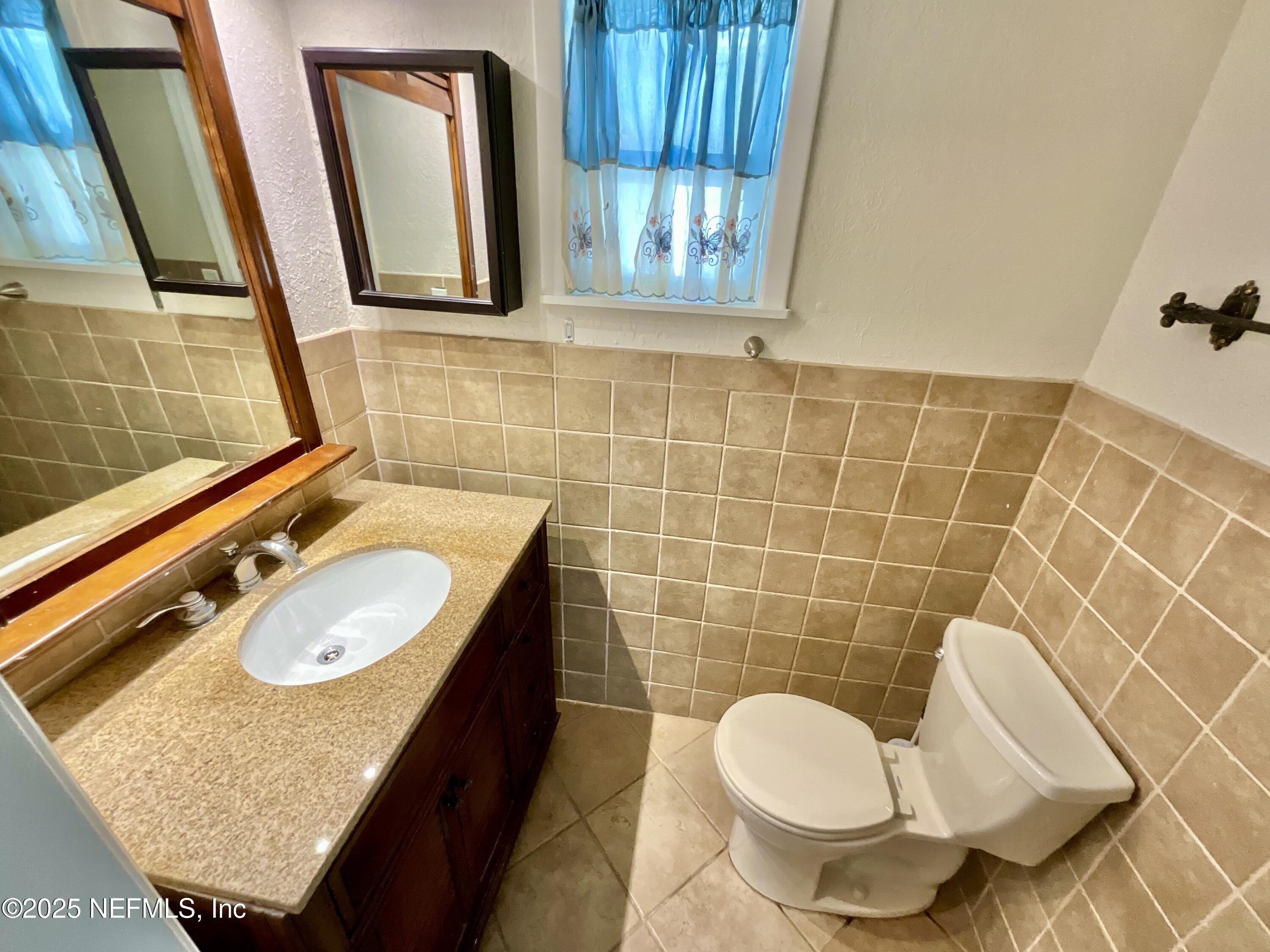 145 Depot Road Hawthorne, FL 32640 - Photo 28 of 73 a bathroom with a granite countertop sink toilet and mirror