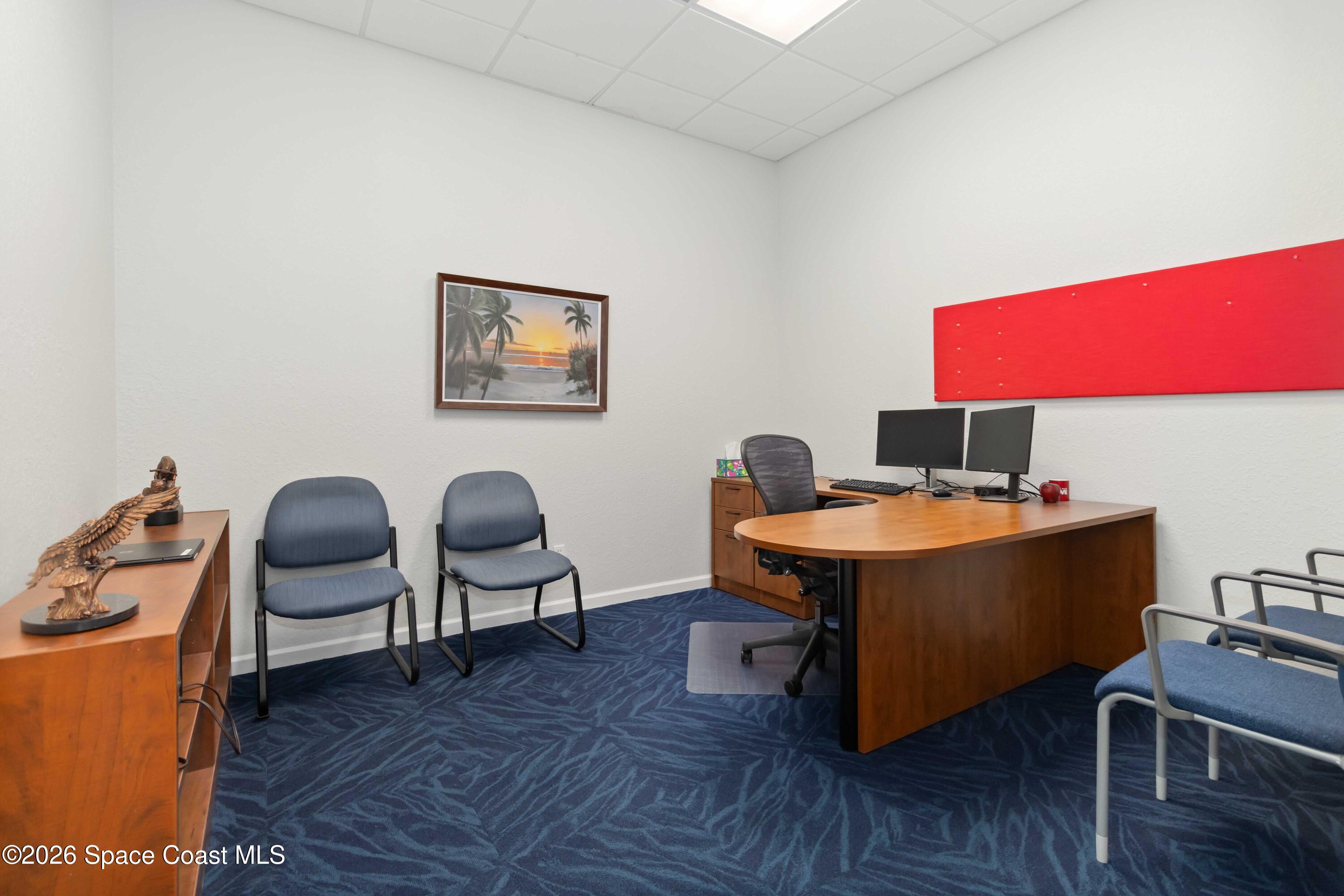 7730 North Wickham Road, Unit 101 Melbourne, FL 32940 - Photo 19 of 48 a view of a workspace with furniture and wooden floor