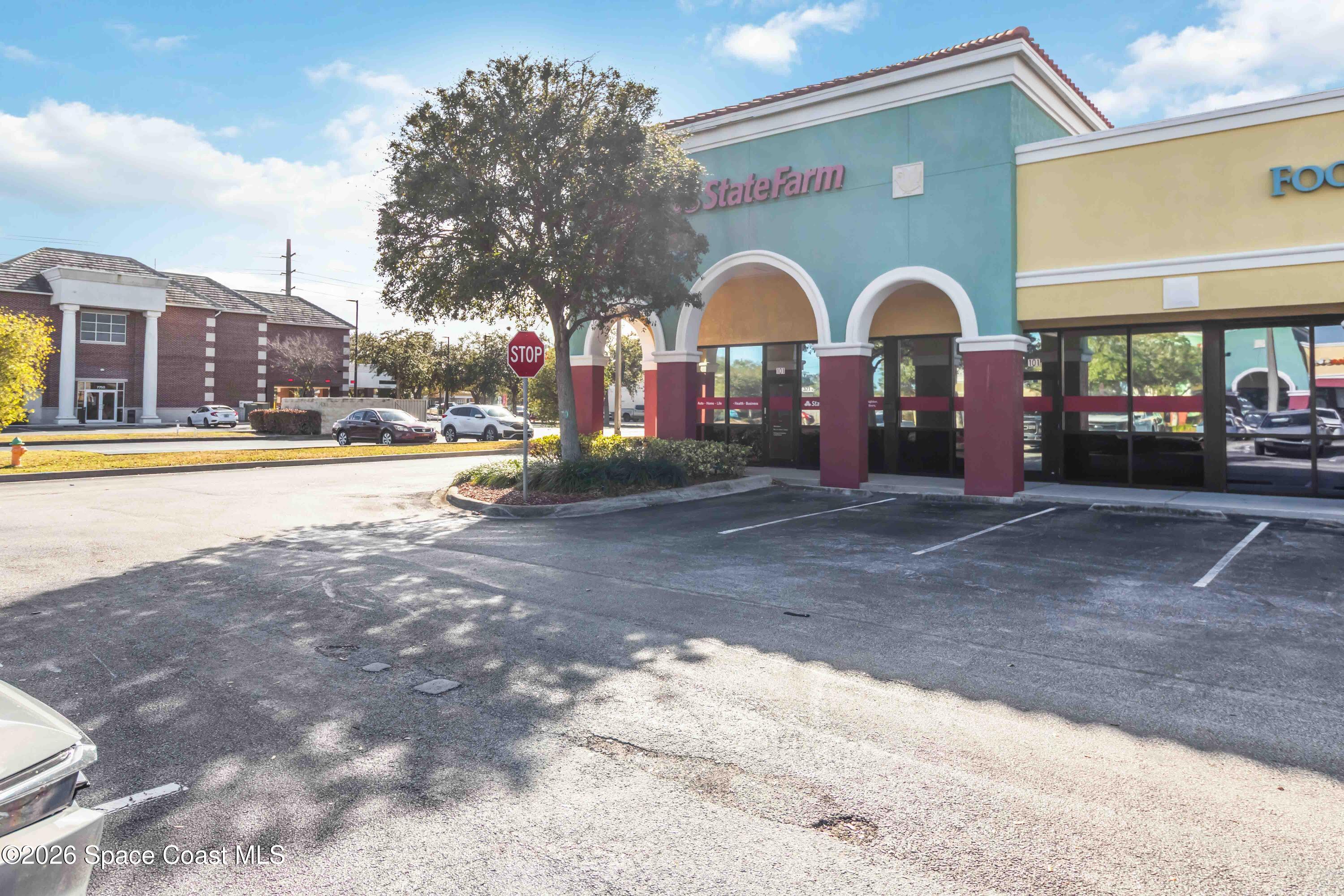 7730 North Wickham Road, Unit 101 Melbourne, FL 32940 - Photo 2 of 48 a front view of a building with garden