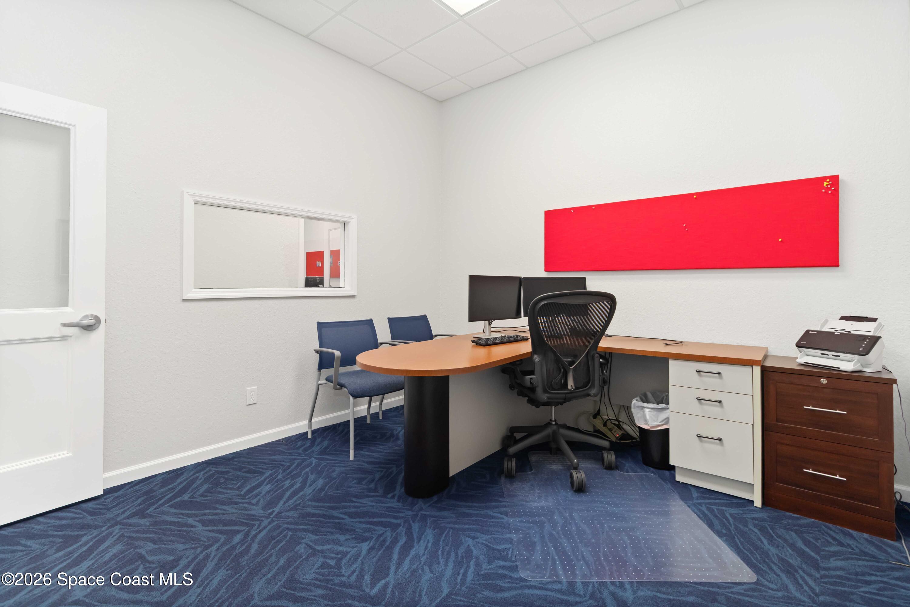 7730 North Wickham Road, Unit 101 Melbourne, FL 32940 - Photo 23 of 48 a view of a workspace with furniture and wooden floor