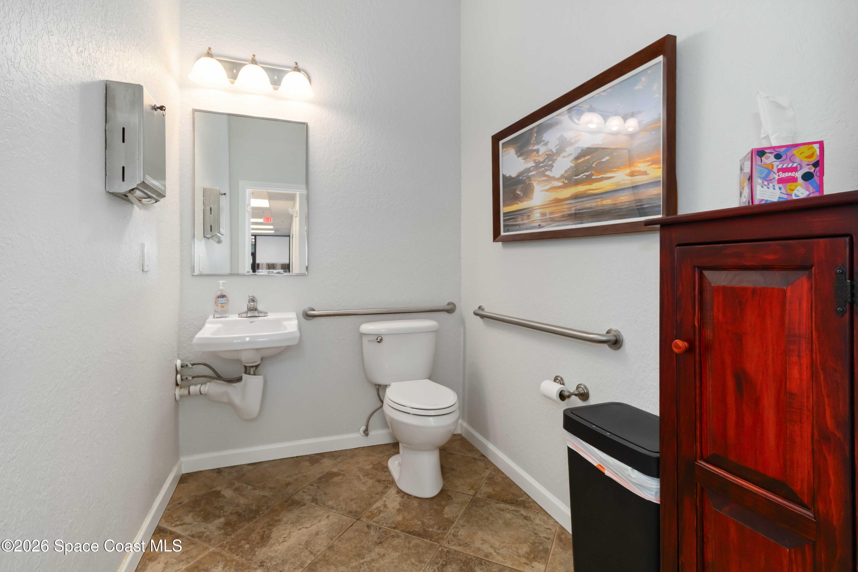 7730 North Wickham Road, Unit 101 Melbourne, FL 32940 - Photo 46 of 48 a bathroom with a toilet a sink and mirror