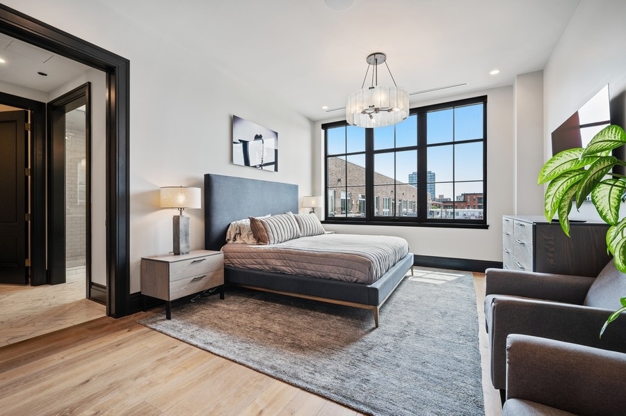 1109 West Washington Boulevard, Unit 4D Chicago, IL 60607 - Photo 16 of 31 a bedroom with a large bed couch and a window