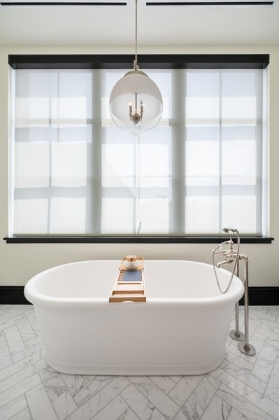 1109 West Washington Boulevard, Unit 4D Chicago, IL 60607 - Photo 19 of 31 a white bath tub sitting in a bathroom next to a window