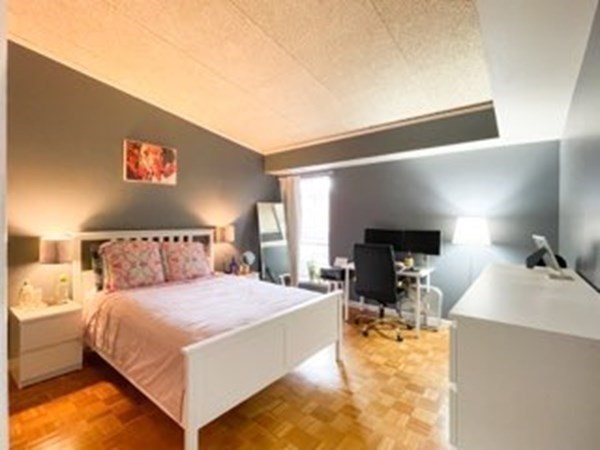 55 Broadlawn Park, Unit S2 Boston, MA 02467 - Photo 8 of 14 a bedroom with a bed and a flat tv screen on dresser