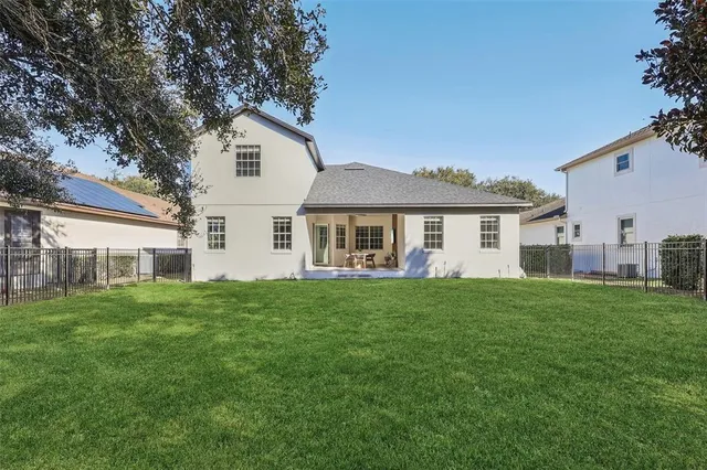 a view of a house with a big yard and large trees