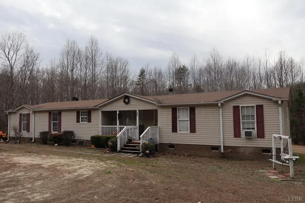 a view of a house with a yard and wooden fence