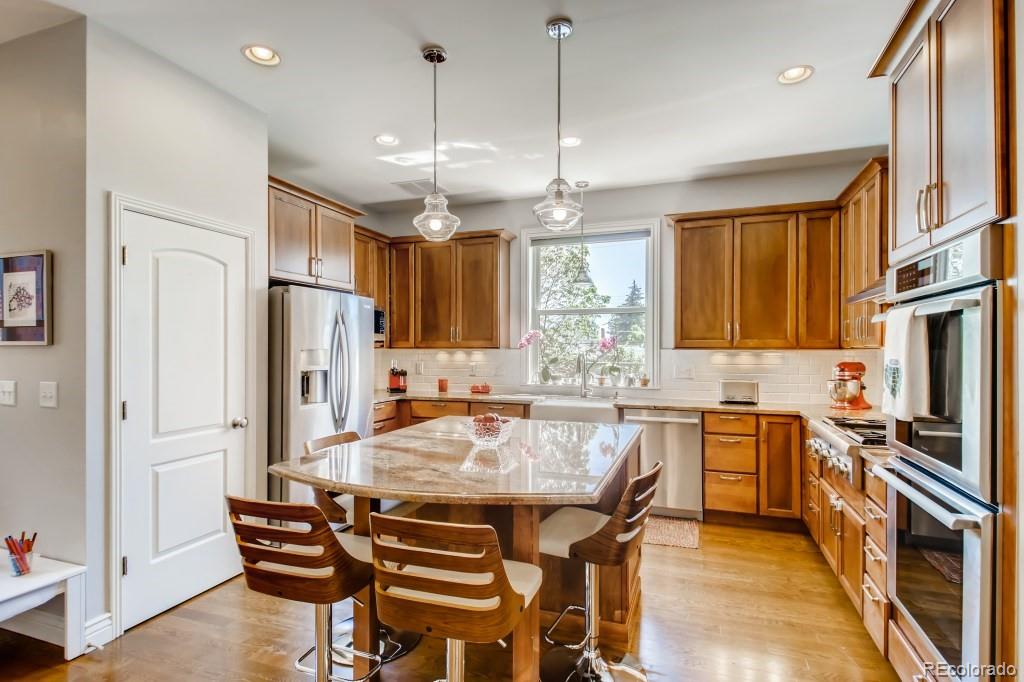 3234 Stuart Street Denver, CO 80212 - Photo 14 of 40 a kitchen with stainless steel appliances a dining table chairs stove refrigerator and kitchen view