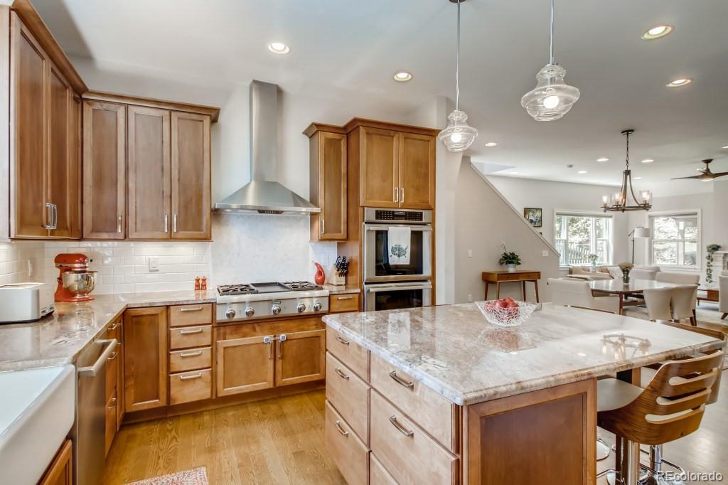 3234 Stuart Street Denver, CO 80212 - Photo 16 of 40 a kitchen with stainless steel appliances granite countertop a sink a stove and a wooden floors