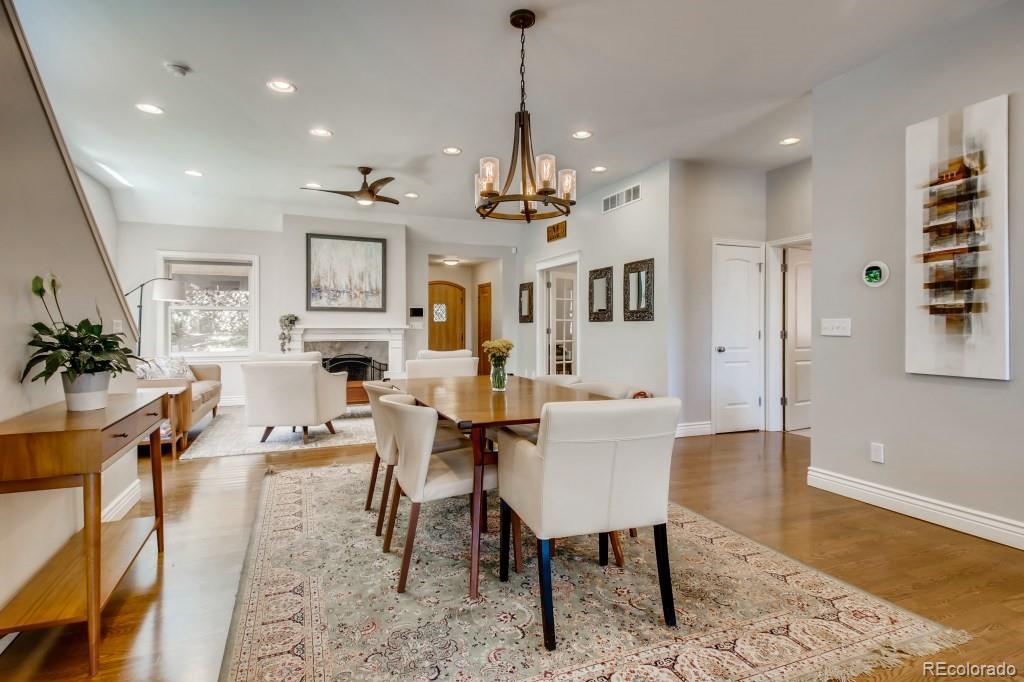 3234 Stuart Street Denver, CO 80212 - Photo 10 of 40 a view of a dining room and livingroom with furniture wooden floor a rug a potted plant and a chandelier