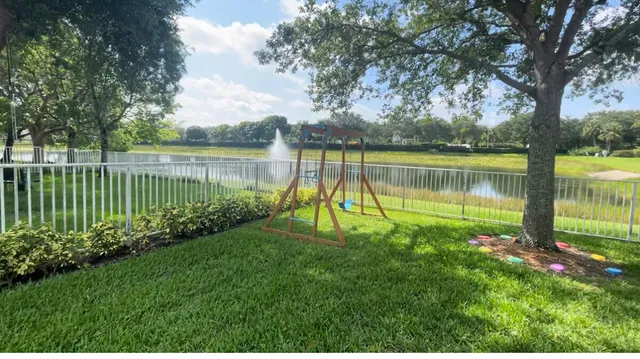 a view of a lake with a big yard and large trees