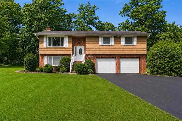 a front view of a house with a yard and garage