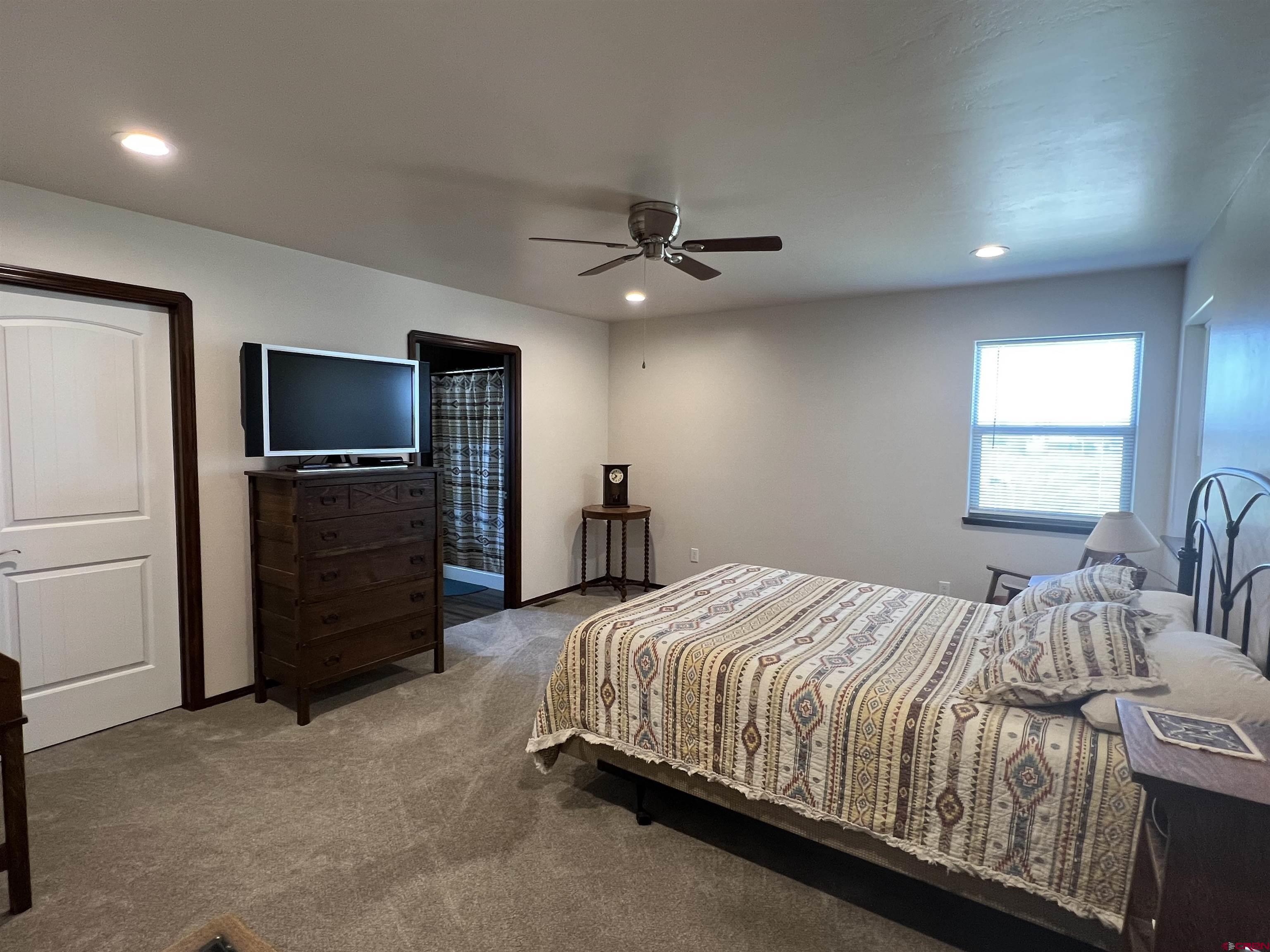 12562 Road 23.25 Loop Cortez, CO 81321 - Photo 11 of 30 a bedroom with a bed and a flat screen tv