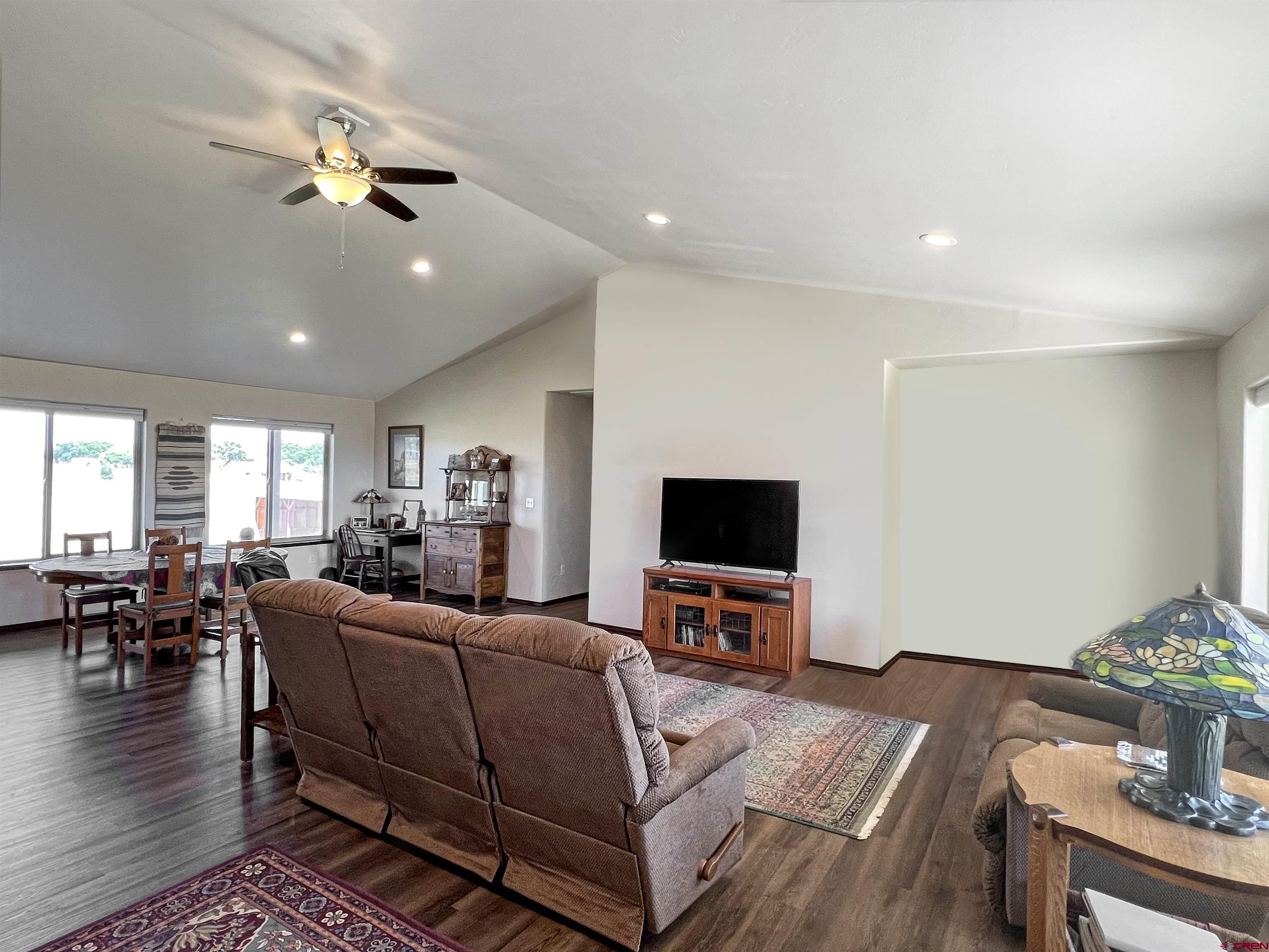 12562 Road 23.25 Loop Cortez, CO 81321 - Photo 3 of 30 a living room with furniture a chandelier and a flat screen tv