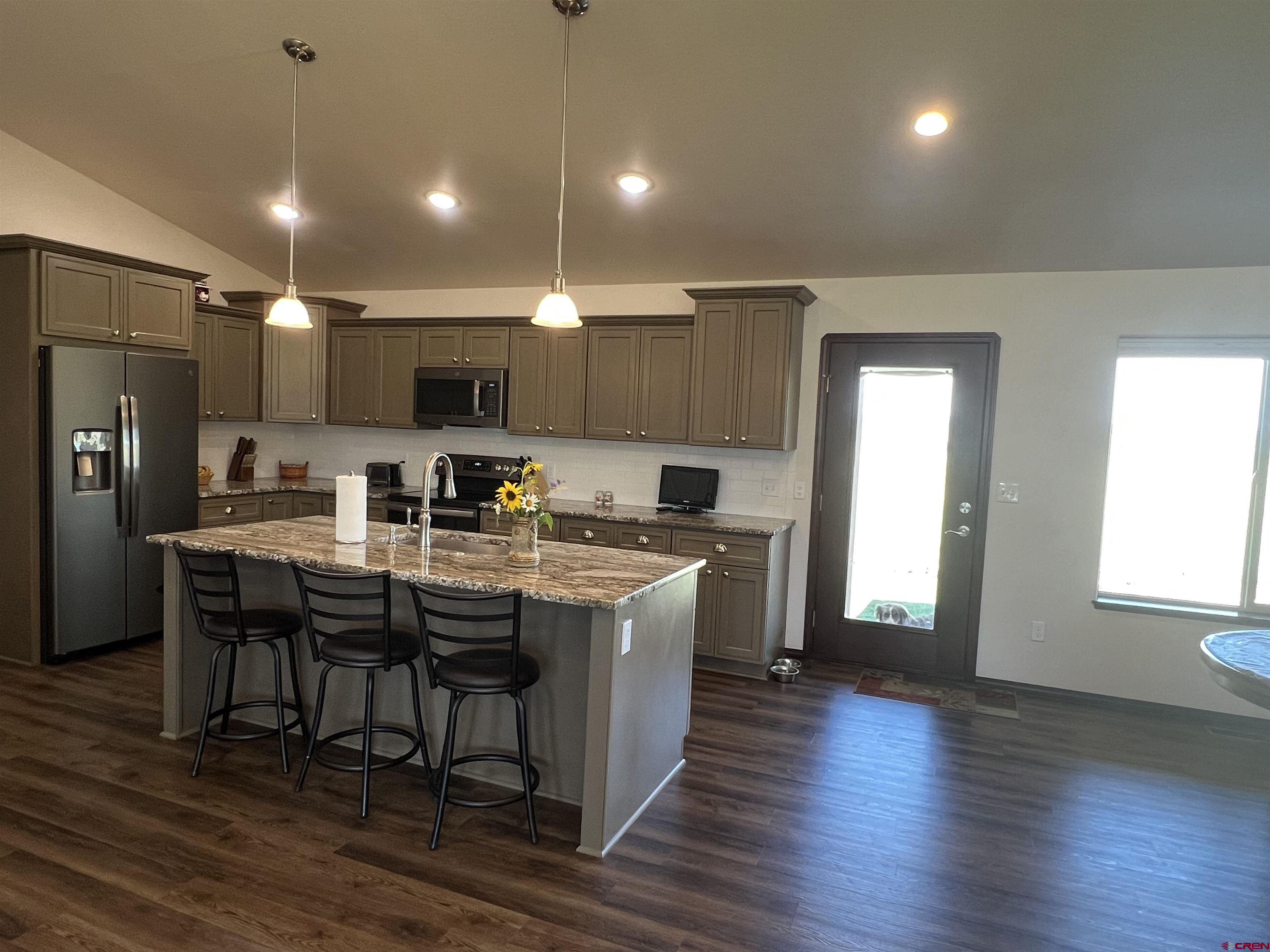 12562 Road 23.25 Loop Cortez, CO 81321 - Photo 8 of 30 a kitchen with kitchen island granite countertop a sink cabinets and wooden floor