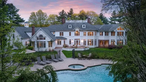 a front view of a house with a yard and lake view