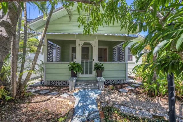 a view of a house with a tree in front of it