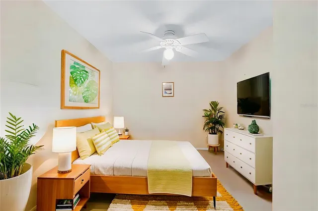 a spacious bedroom with a bed and a flat screen tv