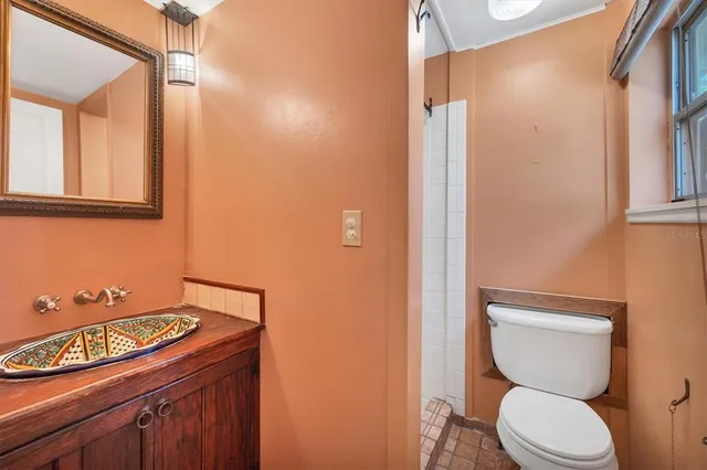 a bathroom with a toilet a sink and mirror