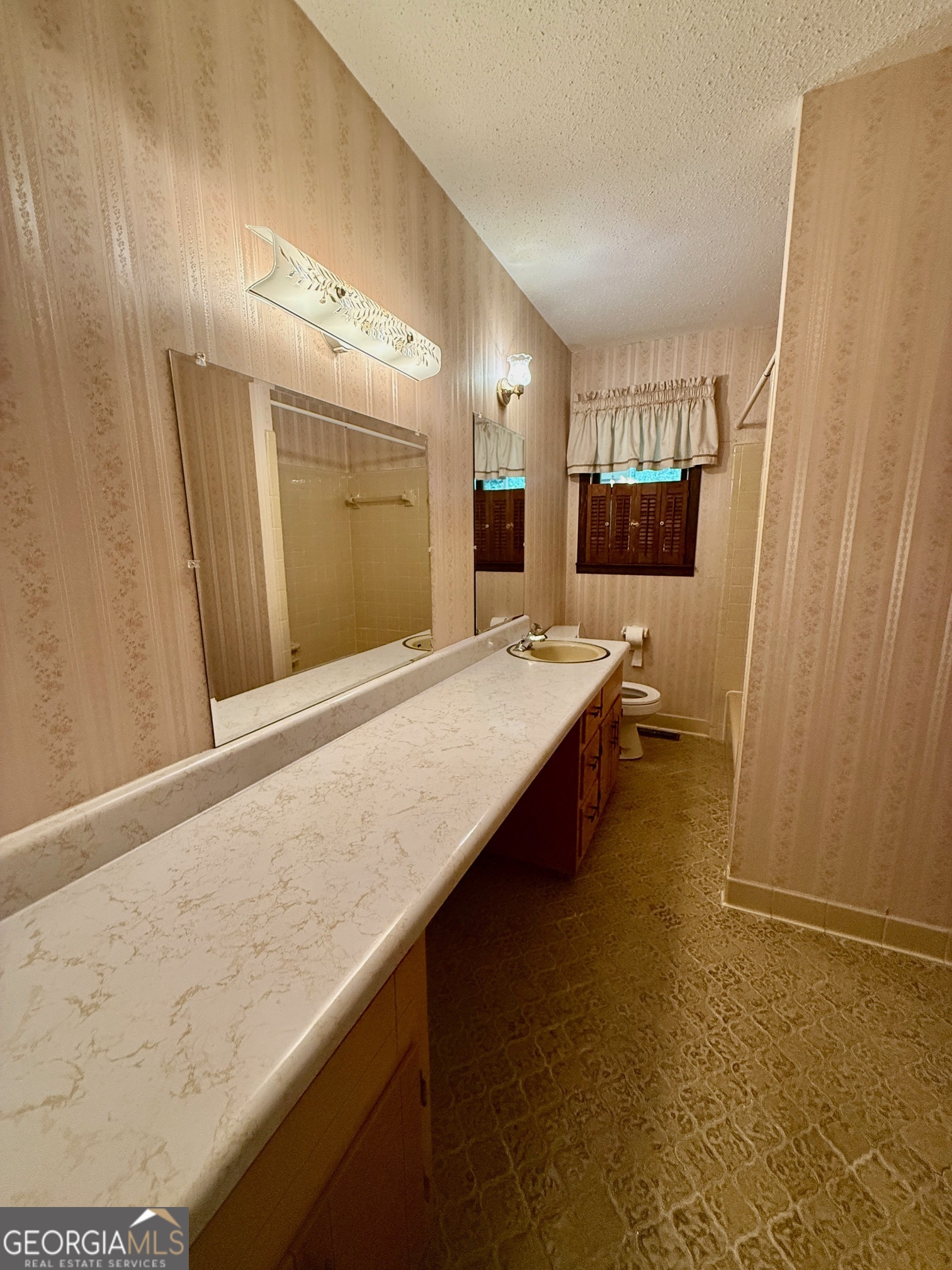 5741 Lawrence Court Macon, GA 31216 - Photo 13 of 22 a bathroom with a granite countertop sink and a mirror