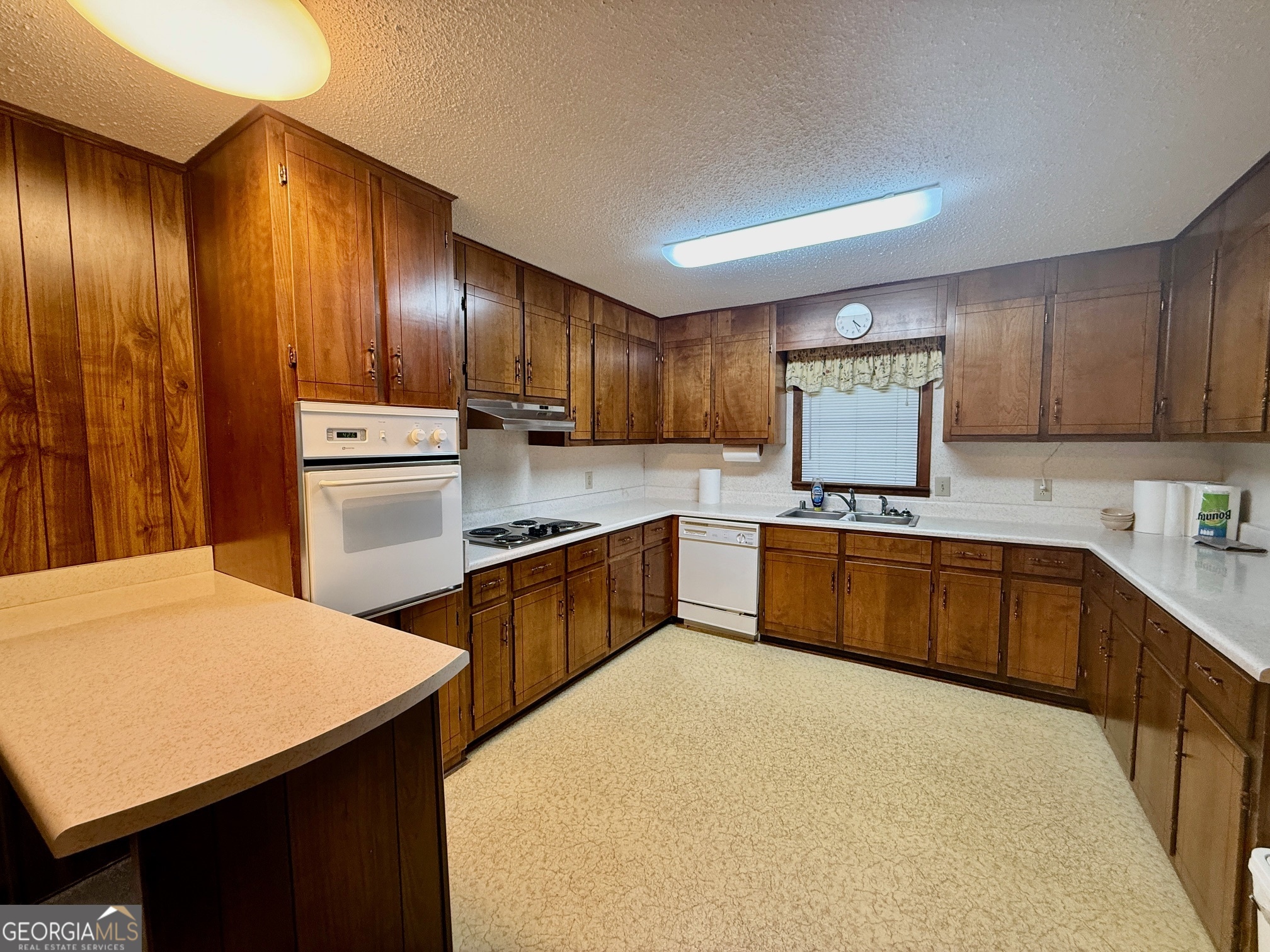5741 Lawrence Court Macon, GA 31216 - Photo 7 of 22 a kitchen with stainless steel appliances wooden cabinets a stove top oven a sink and dishwasher