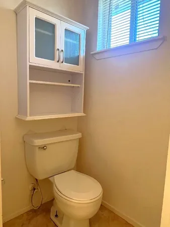 a bathroom with a toilet and a window