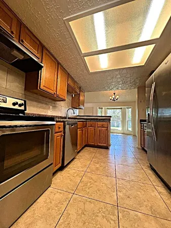 a kitchen with stainless steel appliances granite countertop a stove a sink and a microwave