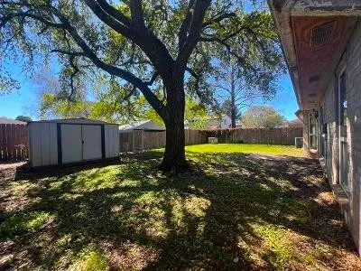 a view of a yard with wooden fence
