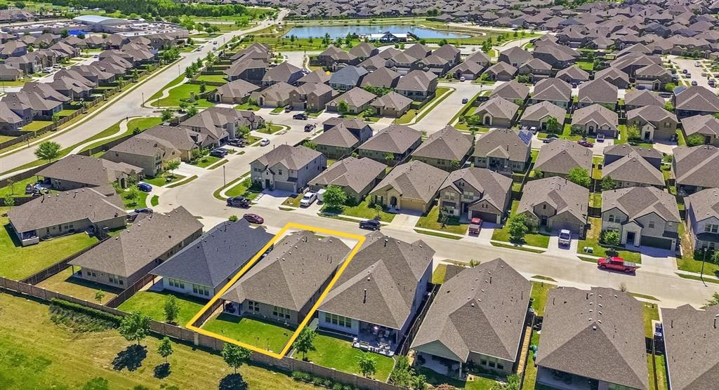 813 Mildren Lane Fate, TX 75087 - Photo 25 of 32 This is an aerial view of the property (outlined in yellow) and its proximity to the pond and clubhouse/pool. Also notice that this home backs to a greenbelt!