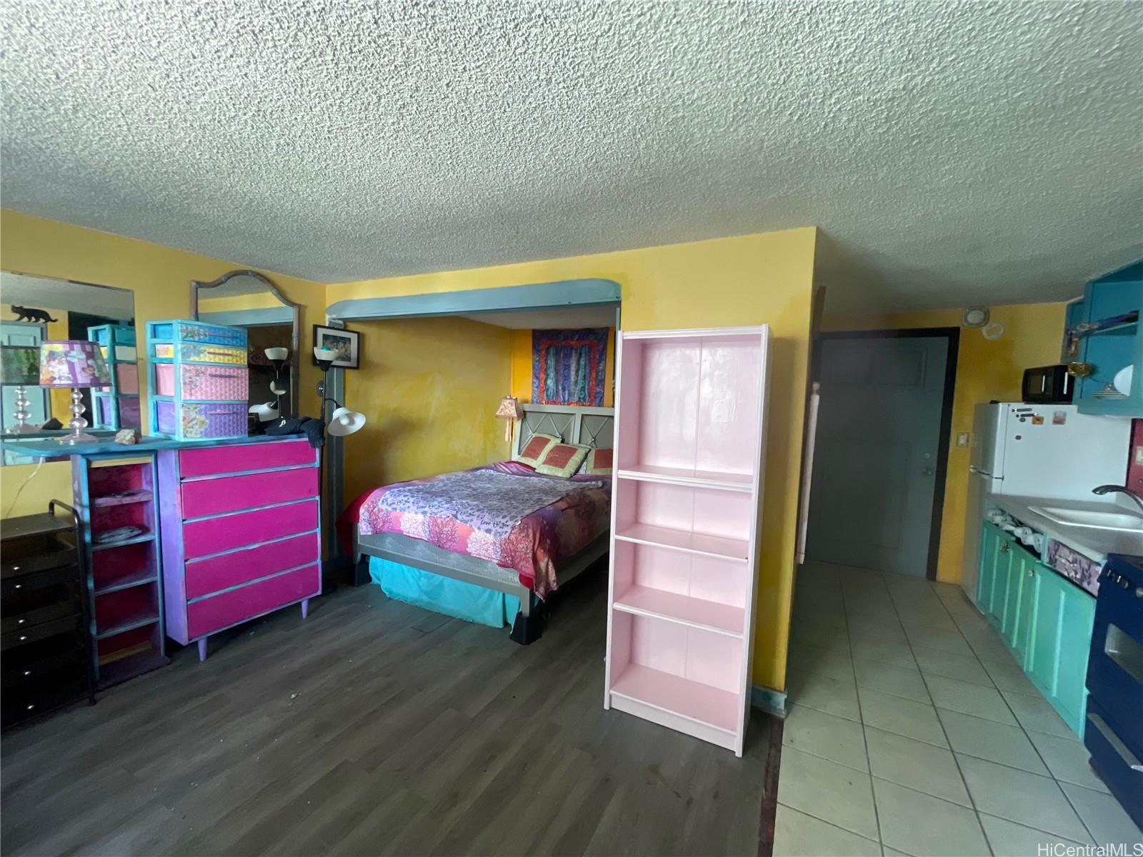 824 Kinau Street, Unit 604 Honolulu, HI 96813 - Photo 4 of 9 a bedroom with a bed and wooden floor