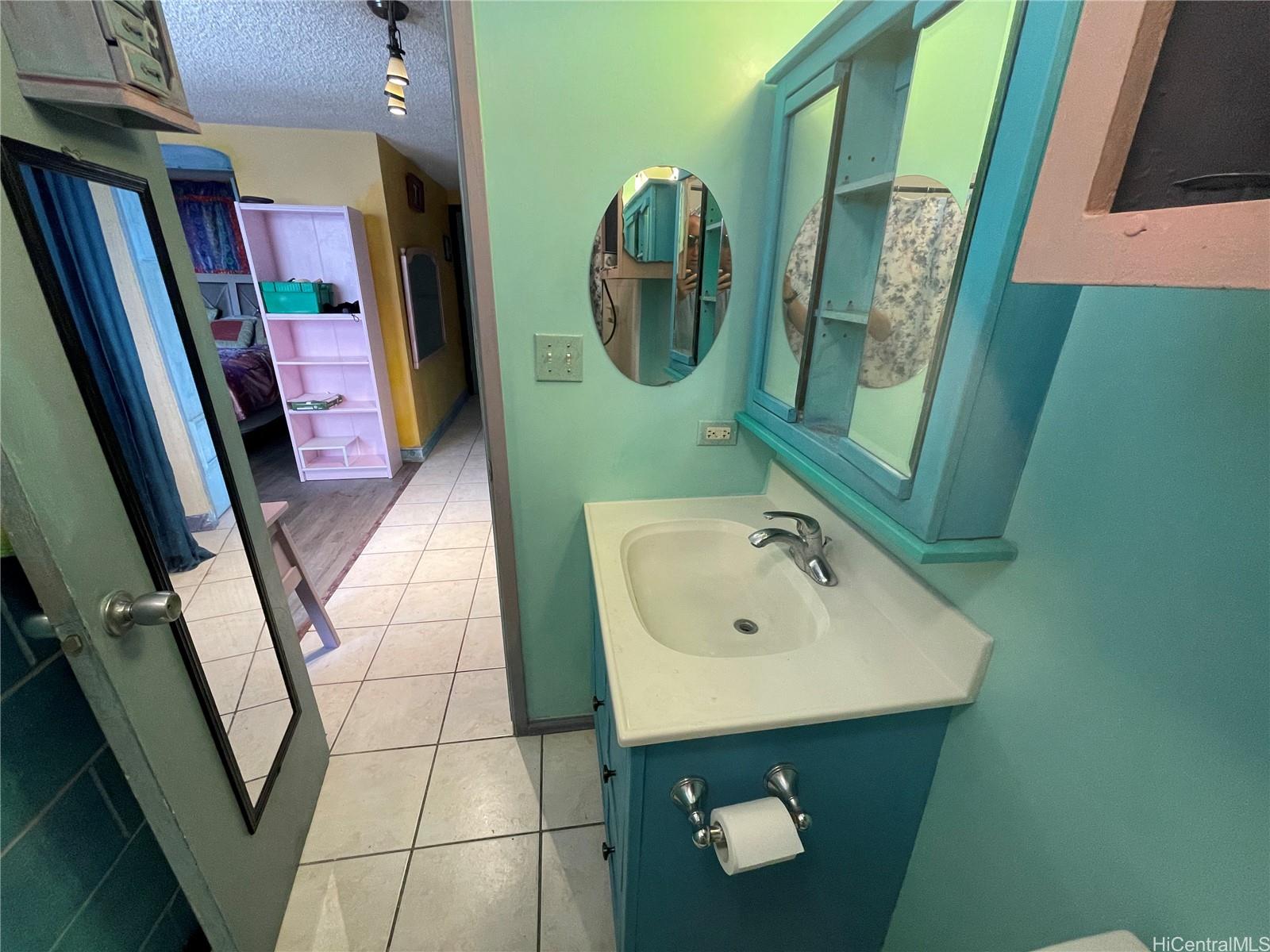 824 Kinau Street, Unit 604 Honolulu, HI 96813 - Photo 6 of 9 a bathroom with a sink and mirror with bathtub