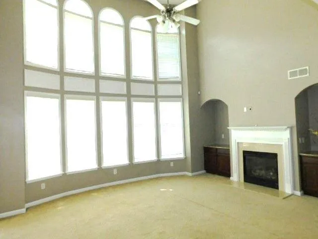 a view of empty room with fireplace and window
