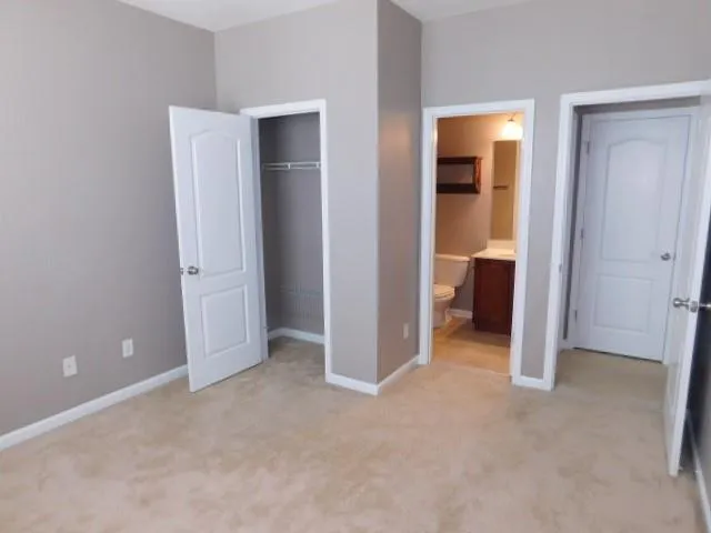 an empty room with closet and a bathroom