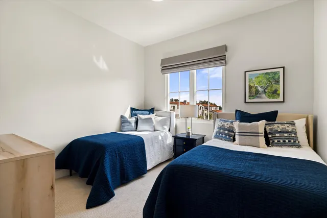 a bedroom with two beds and painting on the wall