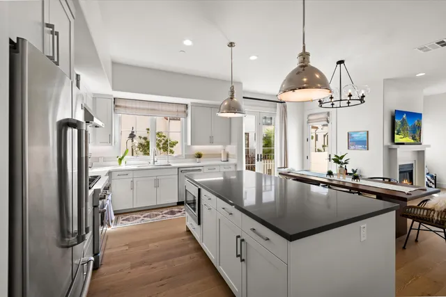 a kitchen with stainless steel appliances granite countertop a sink a counter space and refrigerator