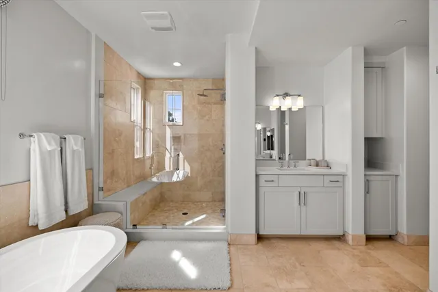 a bathroom with a granite countertop tub sink and mirror